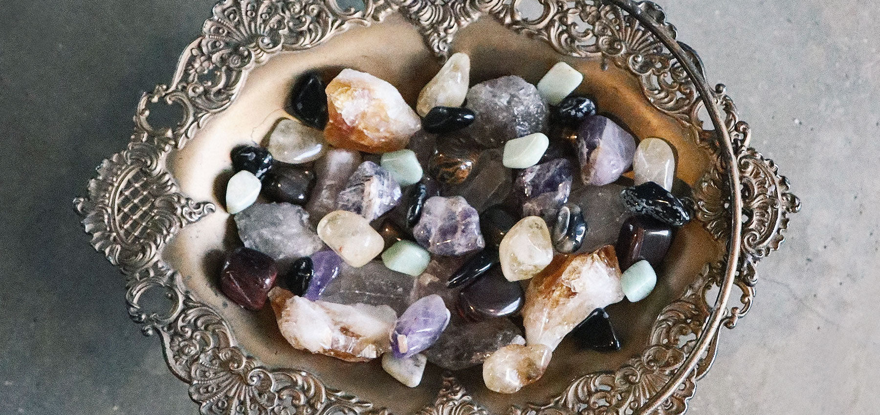 vintage tray filled with tumbled and raw crystals